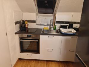 a small kitchen with white cabinets and a sink at Work and Stay Dürwiß IaM Neu Modernisiert in Eschweiler
