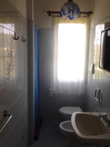 ein Bad mit 2 WCs, einem Waschbecken und einem Fenster in der Unterkunft Hotel Rustichello in Marina di Campo