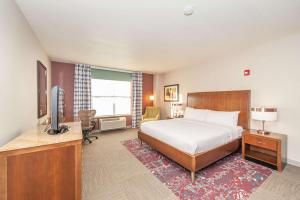 a bedroom with a bed and a desk with a television at Hilton Garden Inn Closest Foxwoods in Preston
