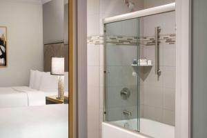 纽约Martinique New York on Broadway, Curio Collection by Hilton的带淋浴和玻璃门的浴室