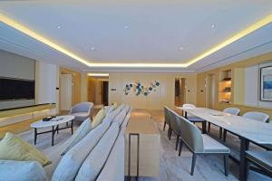 a room with chairs and tables and a flat screen tv at Howard Johnson Glory Plaza Chenghai in Shantou