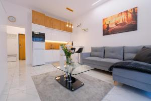 a living room with a couch and a table at Laguna Beskidów Resort - Apartament Perłowy Wellness in Bierna