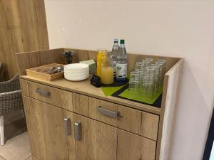 a wooden cabinet with bottles and glasses on it at Hotel Am Schwarzen Berg in Stade +67 photos