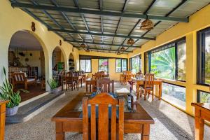 a restaurant with wooden tables and chairs and windows at Blue Star Dive and Resort in Anda