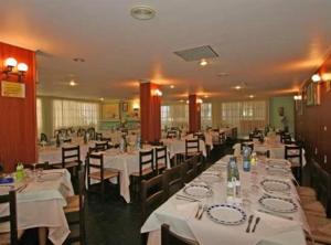 a dining room with tables and chairs with white table cloth at Hotel Sixto in Montalvo