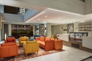 a living room with orange and yellow chairs at Doubletree By Hilton Suites Trabzon Yomra in Trabzon