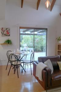 a living room with a couch and a table and chairs at Flaxton Eco-Chic Escape in Flaxton