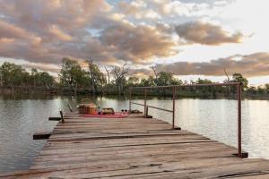 un quai en bois avec un bateau sur l'eau dans l'établissement Maranka Homestead, à Waikerie