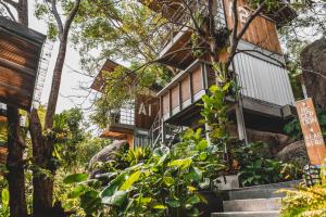 涛岛Shiva Lodge的山上的房屋,有楼梯和树木