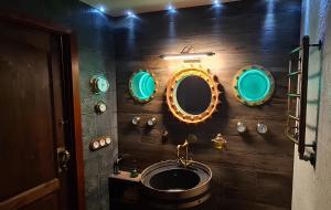 a bathroom with a sink and mirrors on the wall at Narva City - Steampunk in Narva