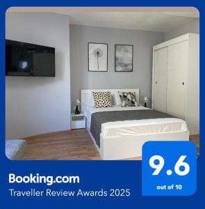 Un dormitorio con una cama blanca y un televisor. en Студио Ирма, en Burgas