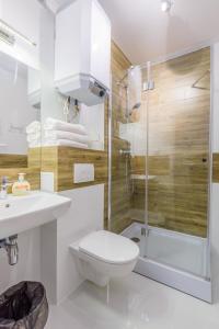 a bathroom with a toilet and a shower and a sink at APARTAMENTY MIERZEJA -BALTIC PARK STEGNA, Przyjazne zwierzętom, 500 m od plaży, Bezpłatny Meleks in Stegna