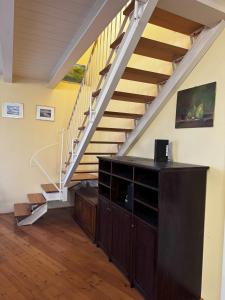 a living room with a staircase and a wooden cabinet at Agriturismo Vivace in Tolentino