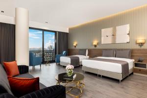 a hotel room with two beds and a couch at Ezkar Bathonea Art İstanbul Hotel in Avcılar