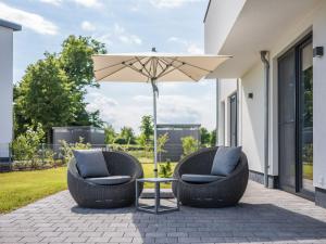 ゲーレン・レビンにあるLuxus-Ferien-VILLA CACCIATOREのパティオ(椅子2脚、パラソル1本付)
