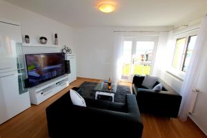 a living room with two couches and a flat screen tv at FERIENHAUS SEENSUCHT in Malchow +12 photos