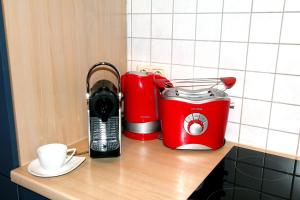 a red toaster and a toaster on a counter at FERIENHAUS SEENSUCHT in Malchow