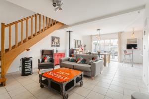 a living room with a couch and a table at Maison entre plage et marais in Bourcefranc