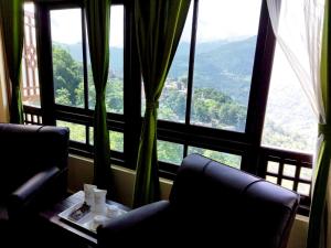 a room with two chairs and a table in front of a window at Hangsaha Regency in Gangtok +17 photos