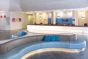a living room with a blue couch in a building at Leonardo Club Tiberias - All Inclusive in Tiberias