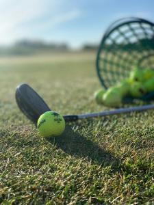 a tennis racket and a ball on the grass at VILLA LIFESTYLE _ HONEYMOON_SUITE in Göhren-Lebbin