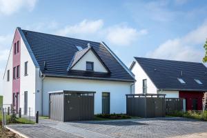 a white house with a black roof at VILLA MON BIJOU _ OG_Fewo in Göhren-Lebbin