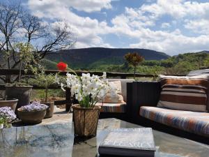 a patio with a couch and a glass table with flowers at Complex Chalet -Turlashkata Kushta in Gabrovo