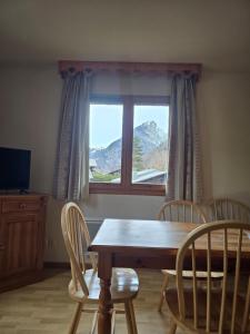 a dining room with a table and chairs and a window at Samoens - E12 in Samoëns