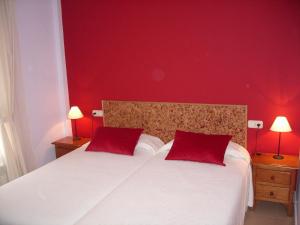 a red bedroom with a bed with two red pillows at El Molino in Castejón de Sos