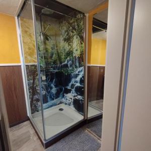 a shower in a room with a painting on the wall at Ferienzimmer am Atelier in Rathenow