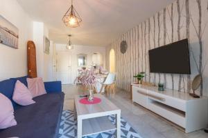 a living room with a blue couch and a tv at Benalmar Playa in Benalmádena