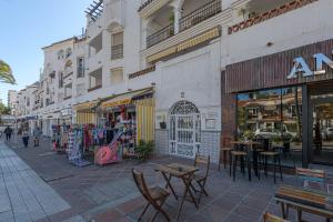 a street with tables and chairs in front of a store at Benalmar Playa in Benalmádena