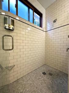 a white tiled bathroom with a shower and a window at Downtown Solvang l Most Desired Home l 2BR in Solvang
