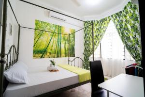 ジョホールバルにある12pax Seri Skudai near UTMの壁に絵が飾られたベッドのある寝室