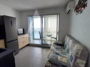een woonkamer met een bank en uitzicht op de oceaan bij T2 vue port de Sete in Sète