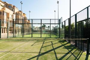 una pista de tenis con red y algunos edificios en Vista Blava, en Denia