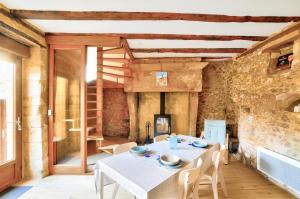 ein Esszimmer mit einem weißen Tisch und Stühlen in der Unterkunft Maison en pierre avec piscine et terrasse pour 6 in Montignac