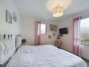 a bedroom with a white bed and a window at Maison avec jardin et jacuzzi pour 8 personnes in Saint-Hilaire-de-Riez