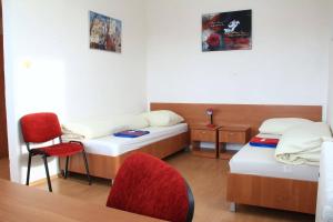 a room with two beds and a table and a chair at Hostel Narva in Bratislava