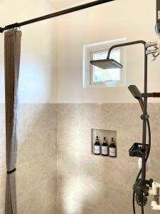 a shower with three bottles of wine in a bathroom at Salamya Guesthouse in San Juan +143 photos