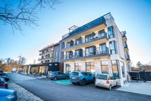 a building with cars parked in front of it at Hotel Royal Bath in Banya