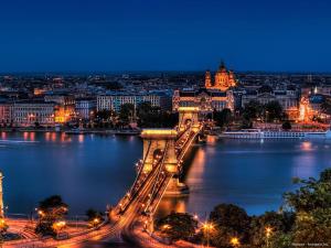 a view of a bridge over a river at night at Louis Apartment in Budapest