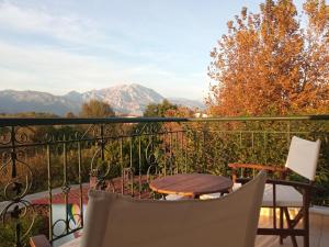 a balcony with a table and chairs and mountains at Η Αυλή in Aridaia