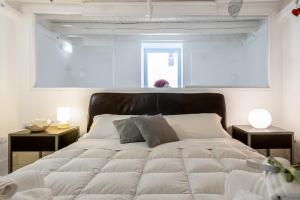 a bedroom with a large white bed with two tables at Riccardo Luxury Apartment in Bari