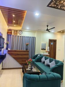 Una sala de estar con un sofá verde y un televisor. en Kartikey Home Stay, en Varanasi