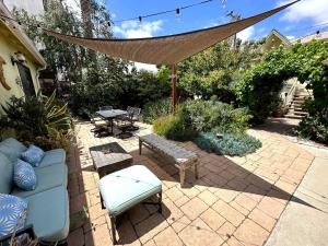 a patio with a couch and chairs and a hammock at Couples Cottage l Steps to Downtown in Solvang