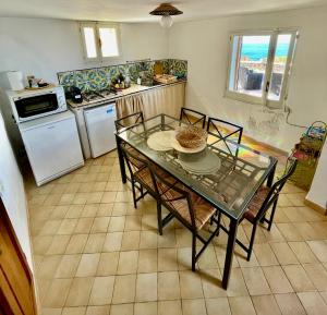 a kitchen with a table and chairs and a kitchen with a stove at Waterfront Villa in Pantelleria