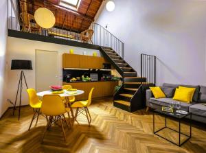 een woonkamer met een tafel en gele stoelen bij Rambaldi Apartments Casa nr 7 in Bardolino