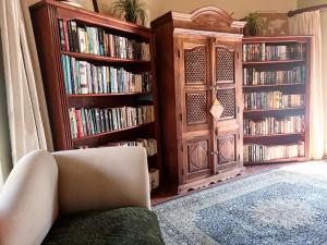 a living room with two large book shelves filled with books at Hawklee Country House in Nottingham Road