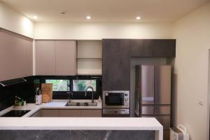 a kitchen with a stainless steel refrigerator and cabinets at Hidden Field Quiet House in Waipu